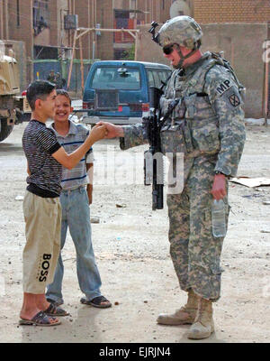 MP soldati instaurare un rapporto con i cittadini iracheni Spc. Concessione Okubo Giugno 06, 2008 Staff Sgt. Douglas Ferguson, una foresta Ranch, California, nativo e un non-ufficiale incaricato con la polizia militare plotone, speciale vigili del Battaglione, quarta brigata Team di combattimento, decimo Montagna divisione Luce, Division-Baghdad multinazionali, riproduce il pollice guerra con un bambino iracheno in un quartiere vicino al funzionamento in avanti base, 31 maggio. Foto Stock