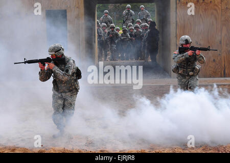 Stati Uniti Il personale dell'esercito Sgts. Patrick Sumey e Terry Cooper, entrambi istruttori per la pre-DISTRIBUZIONE ASSISTENZA FORMAZIONE iniziativa elemento, sprint attraverso la nebbia da un barattolo di fumo come gli studenti e i docenti vista dal punto di partenza su Camp temolo, Mich I soldati sono corsi di formazione per la distribuzione da parte di partecipare nella guardia nazionale Foto Stock