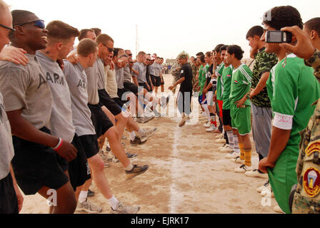 Task Force Vertice battaglia i soldati iracheni sul campo di calcio Staff Sgt. Margaret C. Nelson Giugno 16, 2008 i soldati del primo battaglione, 87th Reggimento di Fanteria intrattenere i figli vincente dell'Iraq soccer team di Riyadh con una danza a seguito della loro, 4-1, sconfitta. Foto Stock