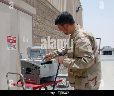 Tecnico informatico Martin Barnoski, distribuito un dipartimento dell'esercito civile, utilizza aria compressa per pulire una stampante di computer, 24 giugno 2008, presso il Camp Arifjan in Kuwait. Barnoski è un membro dell'U.S. Esercito comando Communications-Electronics la gestione del ciclo di vita il comando in avanti attività di riparazione in Kuwait. Conosciuto come il "Tobyhanna FRA", il team di volontari da Tobyhanna Army Depot, Pa., fornisce un supporto di manutenzione per le unità in Asia sud-ovest dalla manutenzione dei computer e relativi dispositivi periferici. Il fra personale ha sottoposto a manutenzione e riparato quasi 3.200 articoli di quest'anno. Jim Hinnan Foto Stock