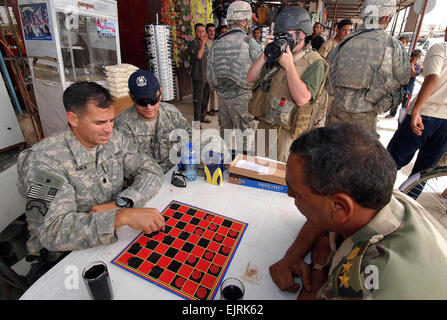 Stelle e Strisce reporter James operaio fotografie un gioco della dama tra Lt. Col. Christopher Vaní?ek, comandante del primo battaglione di fanteria 87th Regt. e Hawijah i figli dell'Iraq contraente Khalaf Ibrahim Ali, in un centro di mercato di recente. Il gioco è stato pensato per aiutare a convincere gli Iracheni locali è il momento giusto per iniziare a condurre una vita normale di nuovo. Il personale Sgt. Margaret C. Nelson vedere: /-news/2008/07/08/10712 pacifica-board-gioco-r... /-News/2008/07/08/10712 pacifica-board-gioco-riflette il calo di violenza in Iraq/ Foto Stock