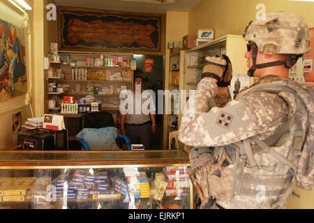 Inoltra una base operativa FALCON, Iraq -- Sgt. Michael Benoit, una scout di cavalleria da Monticello, Minn., assegnato alla truppa C, 7° Stormo, decimo reggimento di cavalleria, 1° Brigata Team di combattimento, 4a divisione di fanteria, Divisione multinazionale -- Baghdad, prende le foto di un locale negozio iracheno agosto 16 come parte dell'applicazione microgrant processo. Soldati di "Comanche" truppa sono iscrizione iracheni locali titolari di azienda da Abu t'shir comunità nel sud di Baghdad Rashid distretto per lo scopo di piccole donazioni aziendali progettato per stimolare il locale economia irachena. Il personale Sgt. Brent Williams, Foto Stock