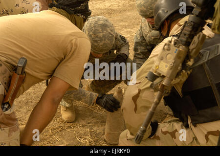 Stati Uniti I soldati della 760th Ordinanza sugli esplosivi società di smaltimento, Ft. Tamburo, N.Y. assistere soldati iracheni dal 8 Divisione esercito iracheno Ordinanza sugli esplosivi team di smaltimento in una zona di scansione sparsi per le munizioni inesplose in un campo aperto durante una cache di armi operazione di ricerca sett. 17, 2008, in West Afak, Iraq. Airman 1. Classe Matteo Plew Foto Stock