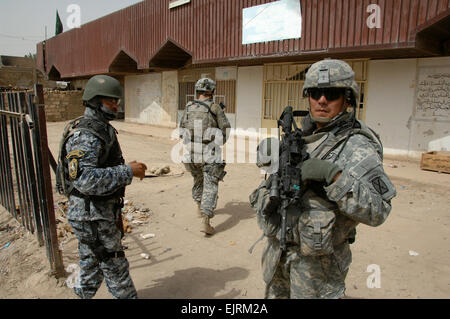 Sgt. Prima Classe Jaime Gonzalez della società Alfa, 2° Battaglione, trentesimo Reggimento di Fanteria, quarta brigata Team di combattimento, decimo Montagna divisione ,un nativo di San Antonio, Texas, diritto che dirige la sua U.S. I soldati iracheni e forze di polizia nazionali durante il funzionamento il cinghiale Bobcats, un cordone e ricerca la missione in Muhallah 762 in Oubaidy, Bagdad orientale, Sett. 28, 2008. Il personale Sgt. Brian D. Lehnhardt Foto Stock