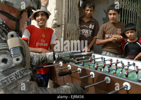 Il personale Sgt. Jon Anderstrom aiuta un'anziana donna irachena attraversare un cordolo mentre si incontra con negozio locale proprietari al mercato di cedro, Mosul, Iraq, Sett. 21, 2008. Anderstrom è assegnato alla società C, 1° Battaglione, 8° Reggimento di Fanteria. Pfc. Sarah De Boise Foto Stock