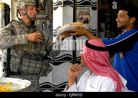 Il personale Sgt. Jon Anderstrom acquista il baklava, dolci di pasta con miele e noci, da un negozio locale mentre si incontra con negozio di iracheni proprietari al mercato di cedro, Mosul, Iraq, Sett. 21, 2008. Anderstrom è assegnato alla società C, 1° Battaglione, 8° Reggimento di Fanteria. Pfc. Sarah De Boise Foto Stock