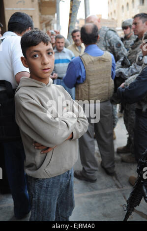 Un ragazzo iracheno orologi come gen. Ray odierno,comandante generale, Forces-Iraq multinazionali, passa attraverso le strade di Samarra in Iraq, su Ott. 29, 2008. Sgt. Ronningen Kani Foto Stock