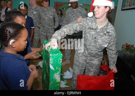 HAMMOND, La. -spc. Sarah R. Garza di Belle Chasse, La., mani doni ai bambini elementari durante un giocattolo di Natale drive dic. 18 presso la Louisiana la scuola per sordi di Baton Rouge, Louisiana. Il teatro 204th Airfield Operations Group in Hammond, La., raccolto più di 100 giocattoli per donare alle elementari di ragazzi e ragazze dormitori. Stati Uniti Il personale dell'esercito Sgt. Stephanie J. Croce, membro dell'aviazione dell'unità di comando gli Affari Pubblici rappresentante Foto Stock