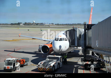 Un EasyJet Airbus A320 attende per i passeggeri con la passerella Ponte fissato alla porta all'Aeroporto di Barcellona, Spagna Foto Stock