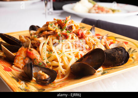 Un piatto colorato mantiene i frutti di mare fra diavolo sopra linguine. Foto Stock