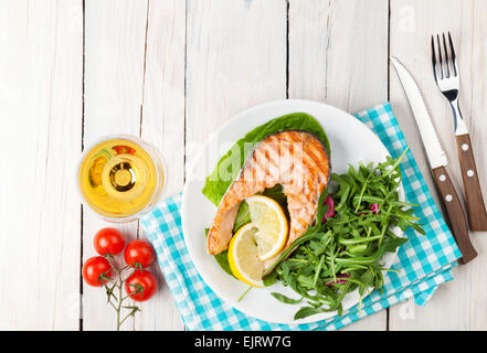 Salmone alla griglia e vino whtie sul tavolo di legno. Vista da sopra con lo spazio di copia Foto Stock