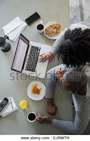Vista aerea del giovane al computer portatile in cucina