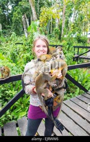 Donna che mantiene circa dieci scimmie scoiattolo in Leticia, Colombia Foto Stock