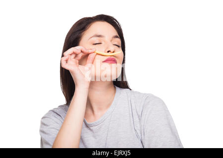 Naturale donna espressiva giocando con patatine fritte, avendo di fronte junk e cibo sano, isolato su bianco Foto Stock