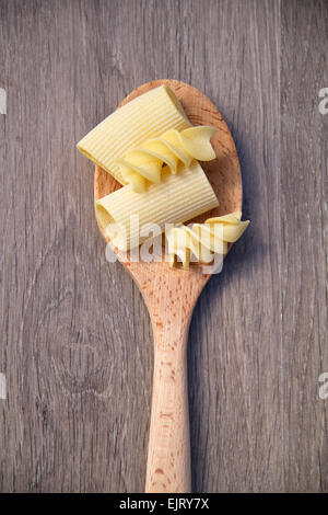 Foto di un cucchiaio di legno con pasta Foto Stock