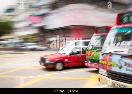 Hong Kong, Hong Kong - 13 Novembre 2014: il movimento sfocati taxi e autobus durante le ore di punta in Hong Kong Foto Stock