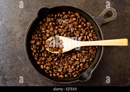 Cucchiaio di campione la tostatura i chicchi di caffè in una padella. Vista superiore Foto Stock