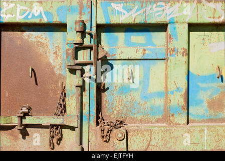 Rusty, corroso vecchia porta di metallo con chiusura a scatto e la catena e i bulloni Foto Stock