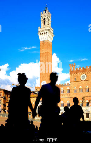 Sagome di turisti di fronte al Palazzo Publico e Torre del Mangia, Siena Italia Foto Stock