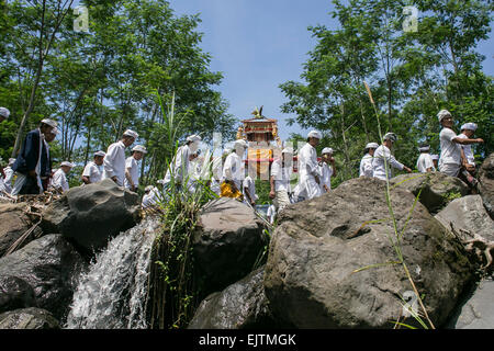 Bali, Indonesia. 1 apr, 2015. Balinese devoti Hindu portano "Pratima' o un simbolo di Dio voce alla molla di acqua per la pulizia cerimonia chiamato 'M' elasticità a Karangasem Regency di Bali. Questa volta in un anno il rituale di purificazione di 'Pratima ' e altri ornamenti sacri si terrà a purificare umano e universo prima di una luna piena cerimonia si trova presso il Gran Tempio di Besakih. Credito: Johannes Christo/Alamy Live News Foto Stock