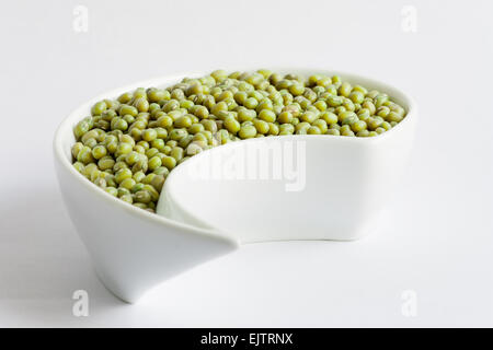 Green piccoli fagioli in bianco vaso in ceramica su sfondo bianco Foto Stock
