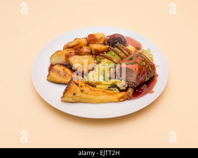 Inglese per la cena carré d'agnello arrosto con patate arrosto Pastinaca Radici di cavolo e il sugo di carne Foto Stock