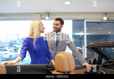 Coppia felice l'acquisto di auto in auto show o salon Foto Stock