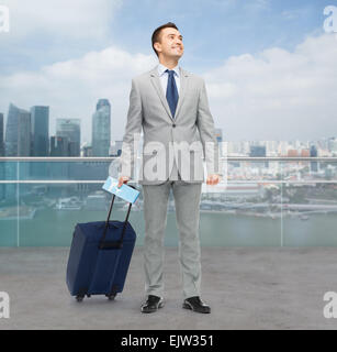 Happy businessman in tuta con borsa da viaggio Foto Stock