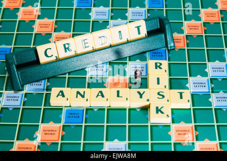 Risk Analyst calcola il credito affidabilità creditizia delle imprese le parole usando piastrelle scrabble a precisare le attività finanziarie Foto Stock