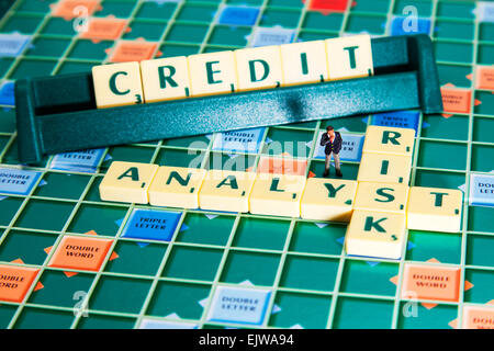 Risk Analyst calcola il credito affidabilità creditizia delle imprese le parole usando piastrelle scrabble a precisare le attività finanziarie Foto Stock