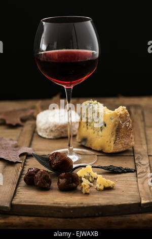 Ancora vita con formaggio e vino rosso sul tavolo di legno, studio shot Foto Stock