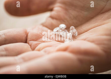 Stretta di mano d'uomo azienda diamanti Foto Stock