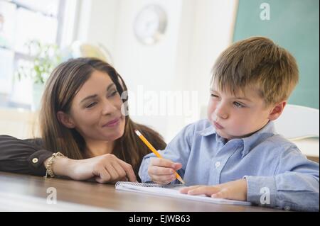 Insegnante femmina e schoolboy (6-7) in aula Foto Stock
