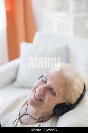 Senior donna ascolto di musica Foto Stock