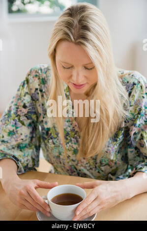 Donna seduta con tazza di caffè Foto Stock