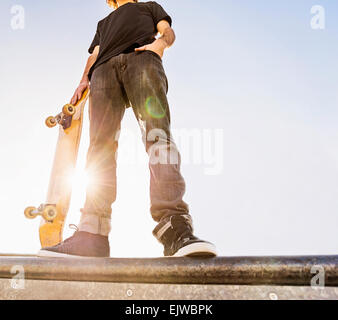 Stati Uniti d'America, Florida, West Palm Beach, Uomo appoggiato su skateboard in skatepark Foto Stock