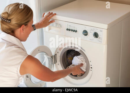 Donna facendo servizio lavanderia Foto Stock