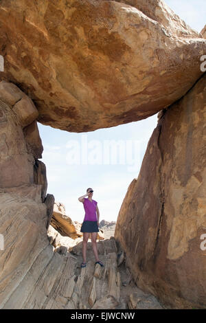 Stati Uniti d'America, Texas, parco nazionale di Big Bend Grapevine Hills, Donna visita Rock equilibrato, guardando attraverso il binocolo Foto Stock