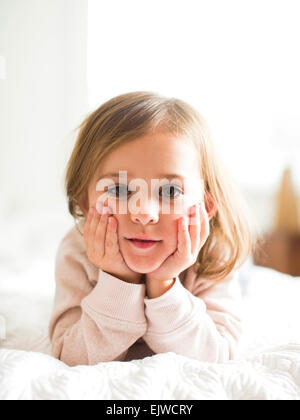 Ritratto di ragazza (4-5) giacente sul letto Foto Stock