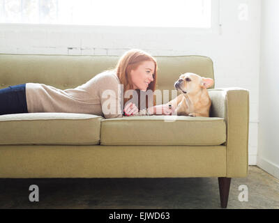 Donna e pug sdraiato sul divano Foto Stock