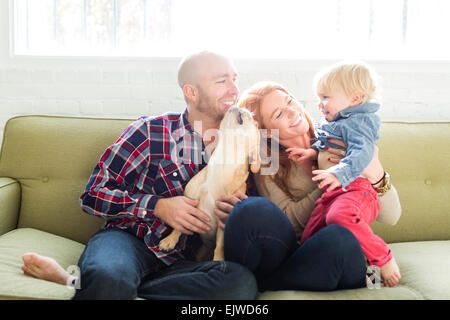 Famiglia con figlio (2-3) e pug sul divano Foto Stock