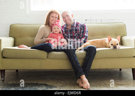 Famiglia con bambino figlio (2-3) e pug sul divano Foto Stock