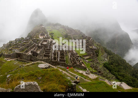 Il Perù, Machu Picchu. La mattina presto le nuvole fagocitato le rovine. Foto Stock