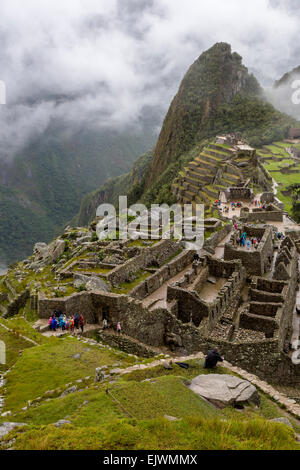 Il Perù, Machu Picchu. Guardando verso il basso sulla parte occidentale del settore urbano, Uña Picchu dietro il Intiwatana (aggancio di Post del Sole). Foto Stock