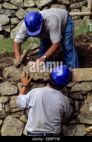 Il Perù, Machu Picchu. La conservazione storica. I lavoratori di ricostruire le pareti da originale crollato pietre. Foto Stock