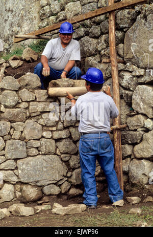 Il Perù, Machu Picchu. La conservazione storica. I lavoratori di ricostruire le pareti da originale crollato pietre. Foto Stock