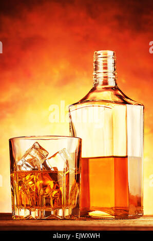 Nobile whiskey in un bicchiere e bottiglia su una tavola di legno Foto Stock