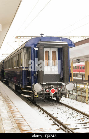 Vista posteriore dell'ultima vettura passeggeri di un treno di stanza presso la stazione ferroviaria Foto Stock