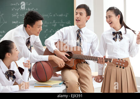 Gli studenti delle scuole superiori di suonare la chitarra in classe Foto Stock