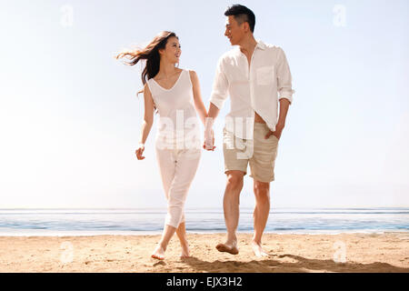 Il romantico giovani amanti holding hands passeggiate in mare Foto Stock